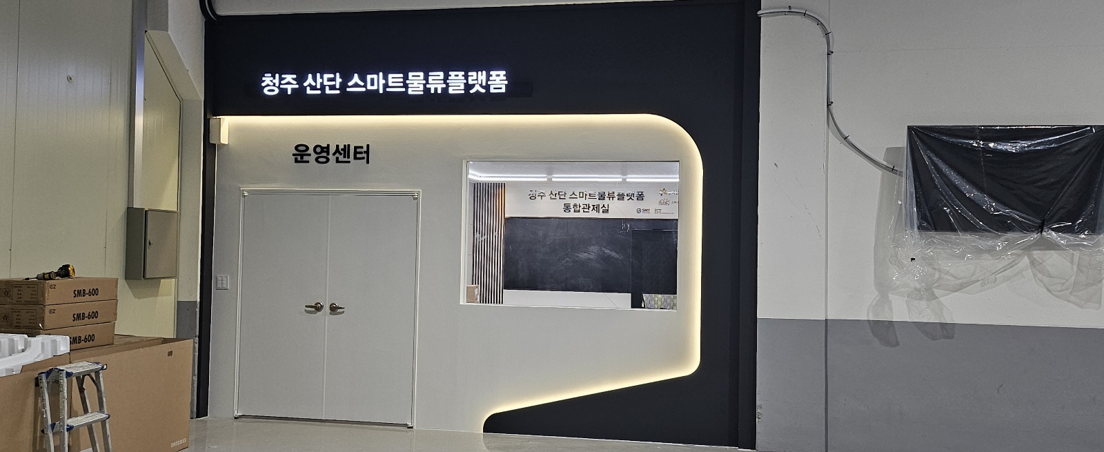 간접조명이 흐르는 곡선 프레임과 운영센터 출입구