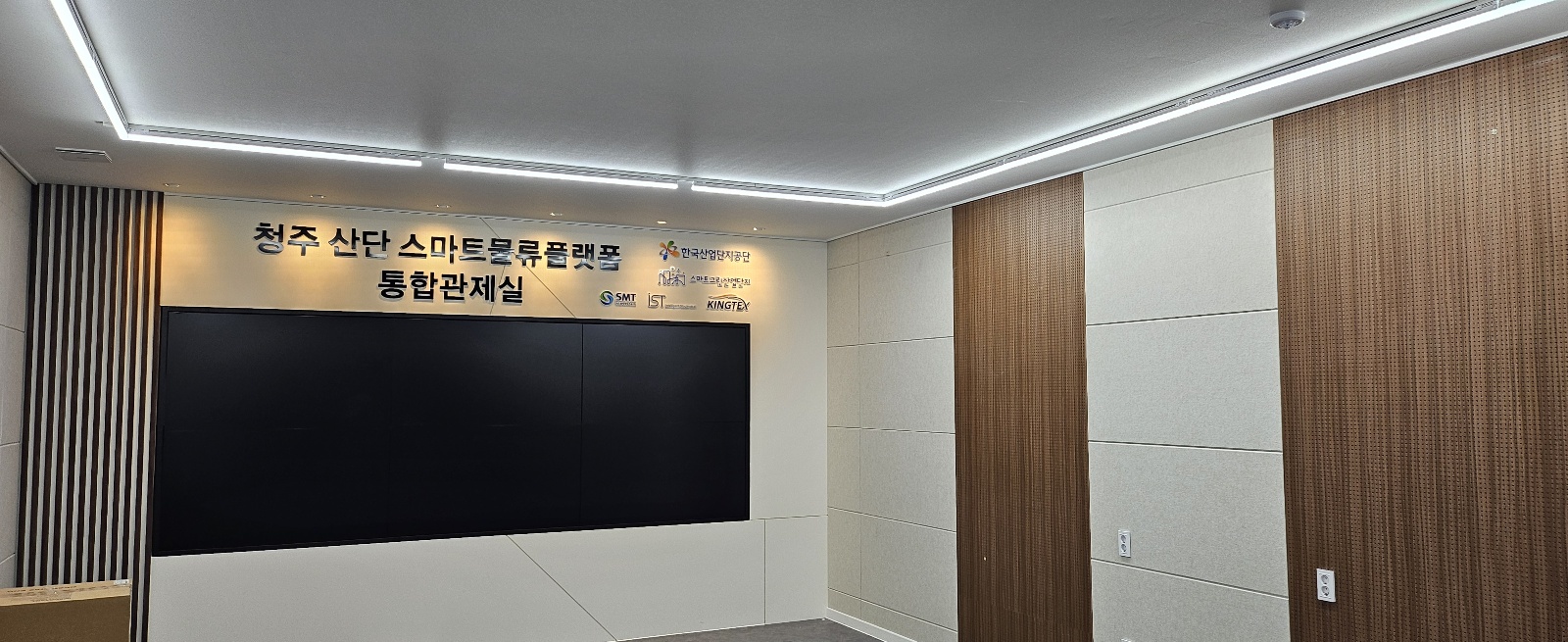 6면 디스플레이와 우드 타공판 벽체가 보이는 청주 산업단지 통합관제실